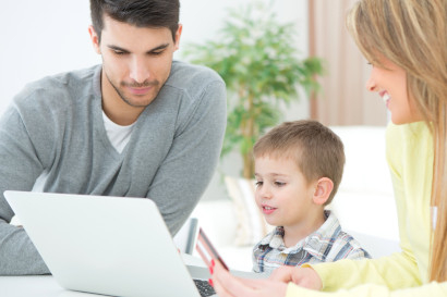 Parents and elementary school student using laptop to purchase item