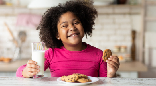 Girl enjoying milk and cookies