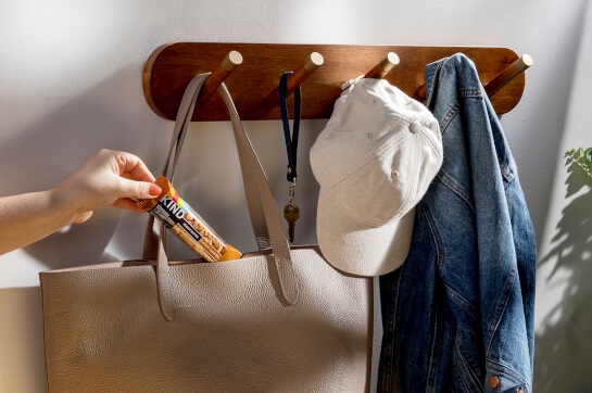 Woman placing snack bar in bag