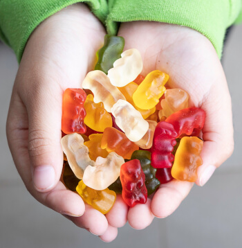 Young Student Holding Gummy Bears