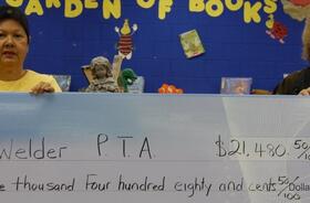 Welder Elementary School PTA fundraising team holding check